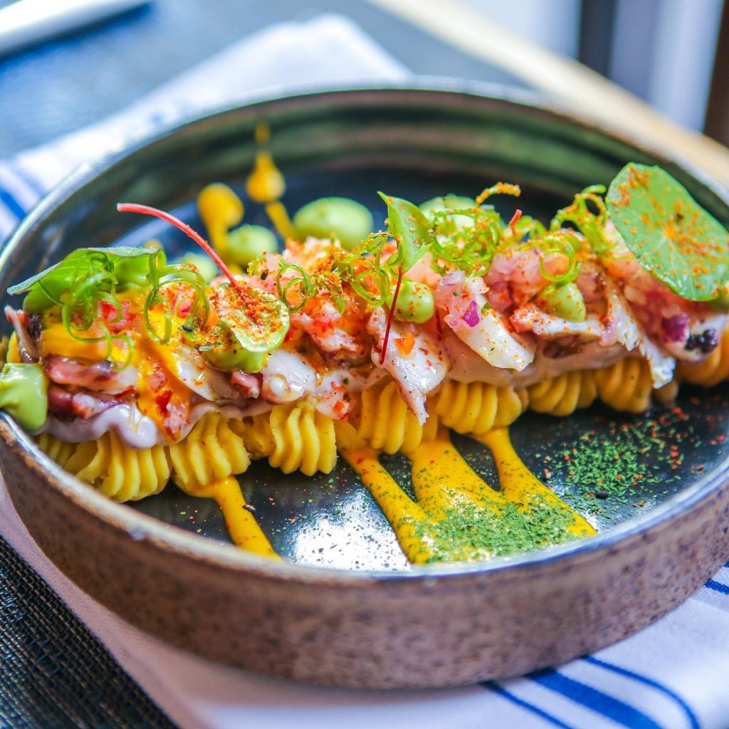 brown bowl of colourful food, yellow, orange and green, best ceviche nyc